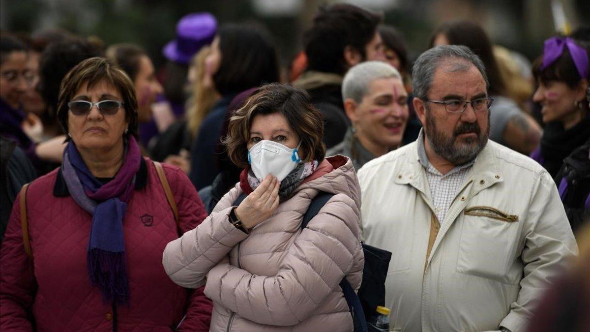 Una participante en la manifestación del 8M en Madrid se protege con una mascarilla por el riesgo de coronavirus