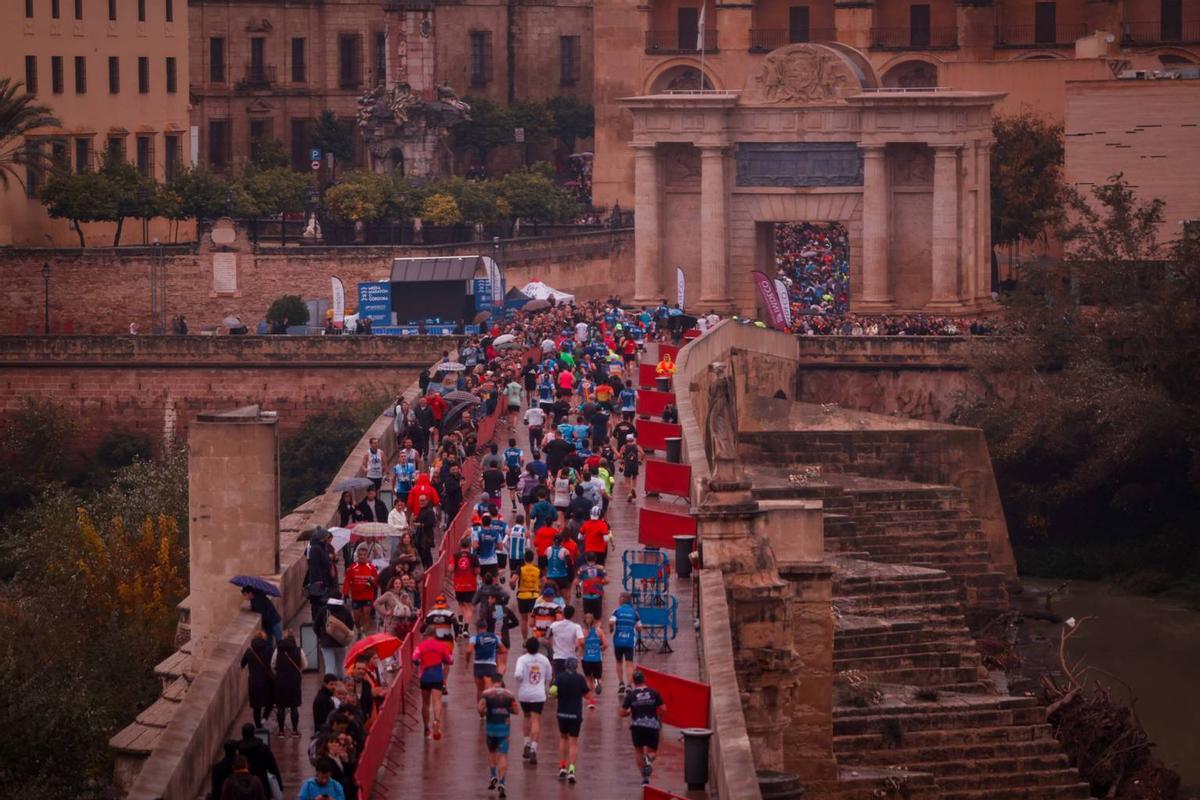 Un grupo de atletas atraviesa el Puente Romano y la Puerta del Puente en la edición del pasado año.
