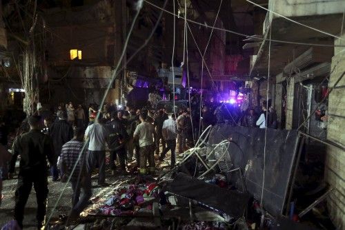 Residents inspect a damaged area caused by two explosions in Beirut's southern suburbs, Lebanon