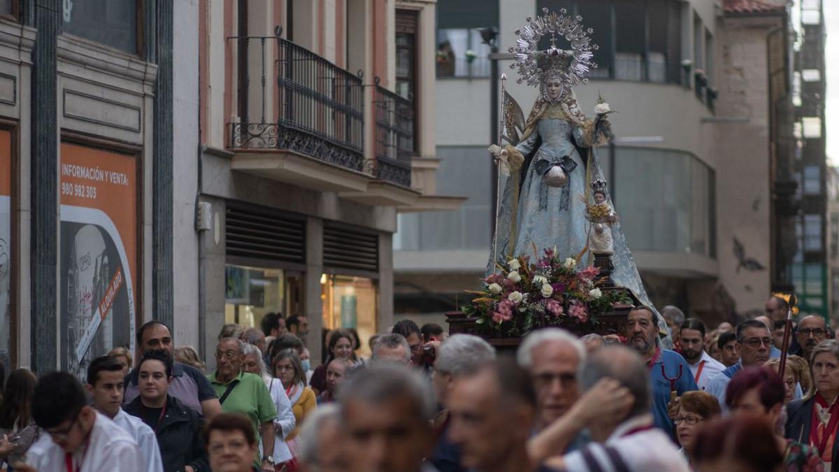 Arriba, la imagen de la Concha rodeada de cofrades transita por Santa Clara. A la derecha, los dulzaineros que interpretaron el himno nacional a la salida de la Virgen y el paso de la comitiva inmortalizado en la Plaza Mayor  | |  E. FRAILE