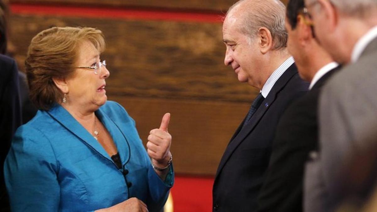 Bachelet (izq) saluda al ministro del Interior español, Jorge Fernández Díaz, este martes en Santiago de Chile.