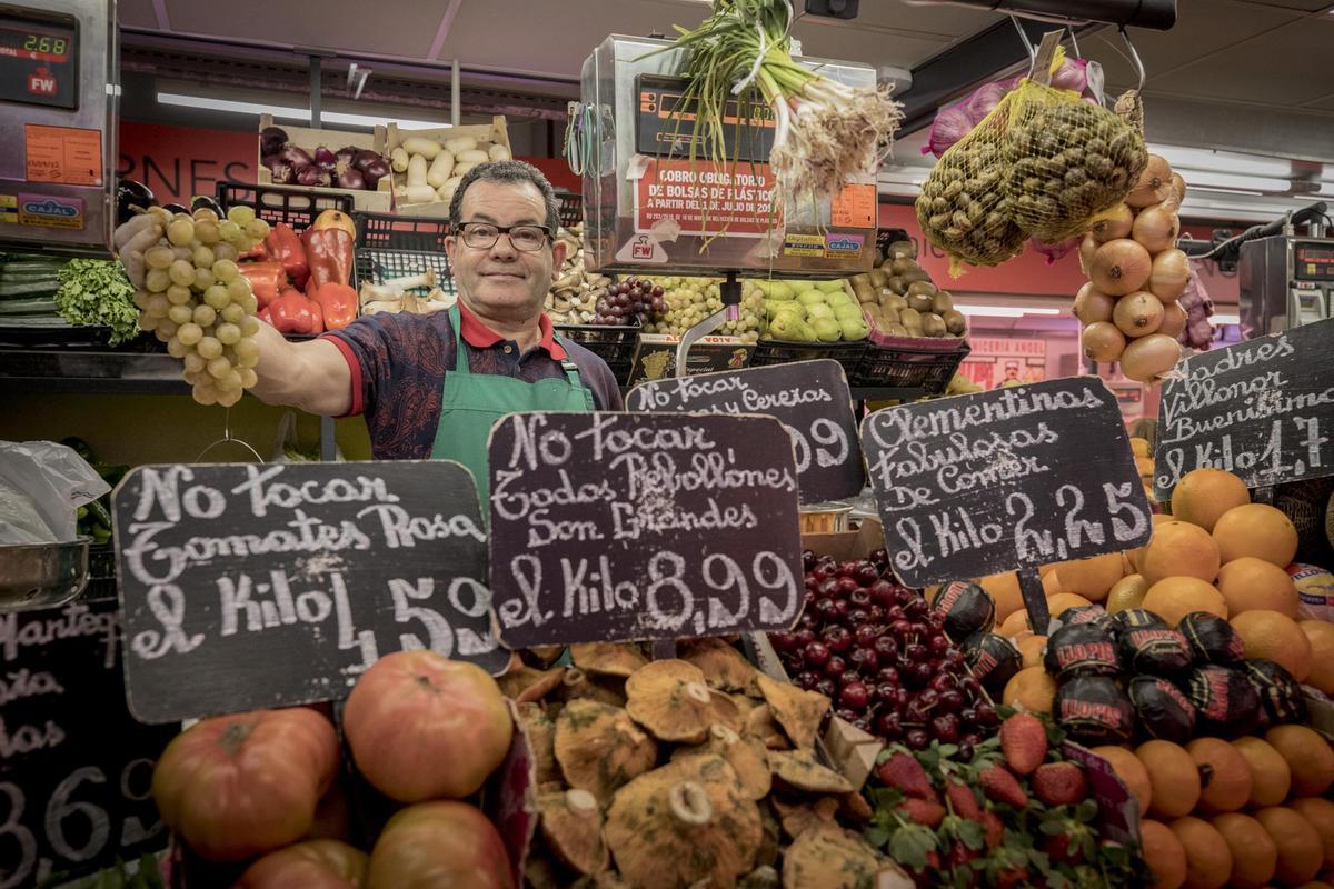 Tendero en un puesto de frutas y verduras de un mercado de proximidad de la ciudad de Zaragoza.