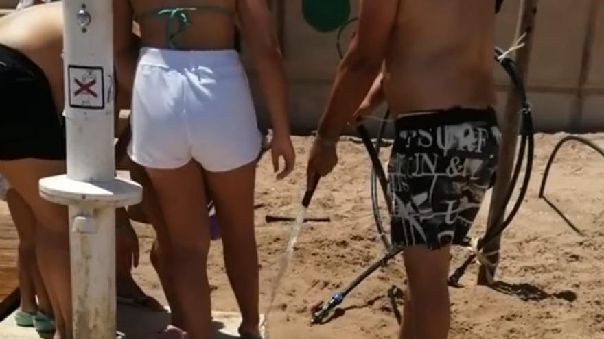 Usuarios de la playa se limpian con mangueras