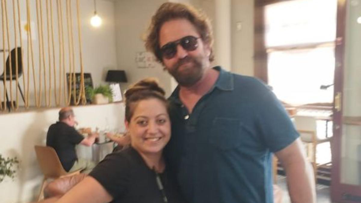 Gerard Butler con una empleada del local Sqina.