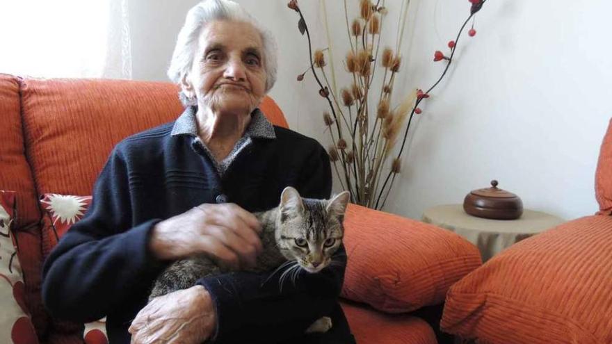 Ana María Bermejo acaricia a su gata en el salón de su casa de Bretocino de Valverde.