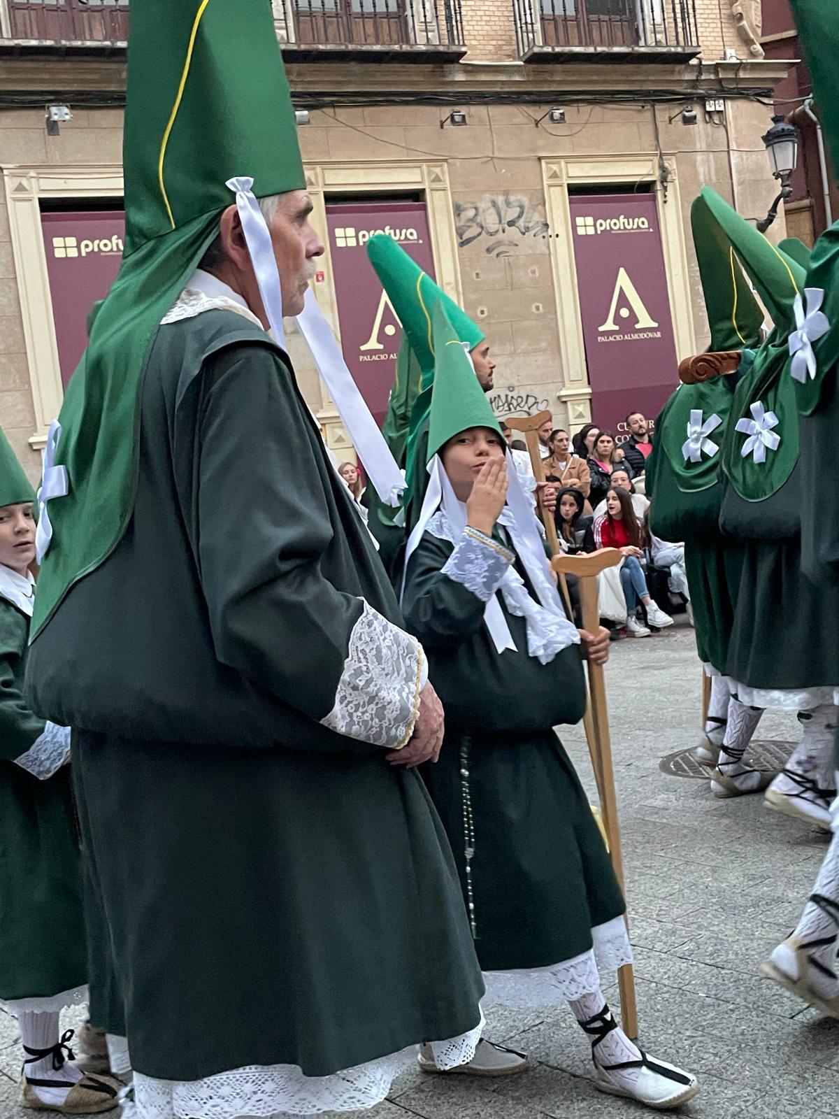 Un joven estante lanza un beso al público durante la procesión de Domingo de Ramos en Murcia