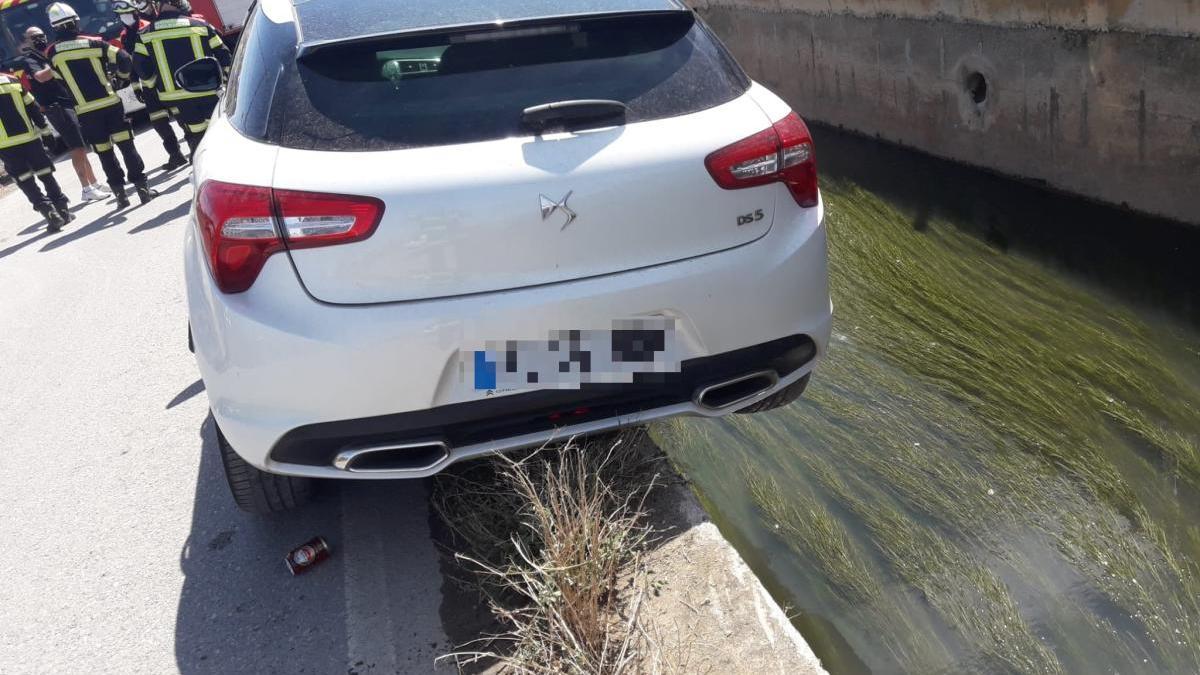 Los bomberos rescatan a un conductor a punto de caer a la acequia