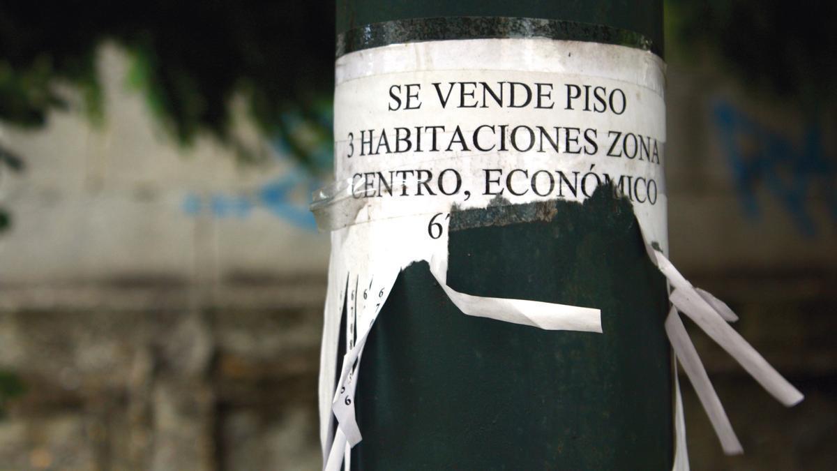Cartel de venta de piso en una farola.