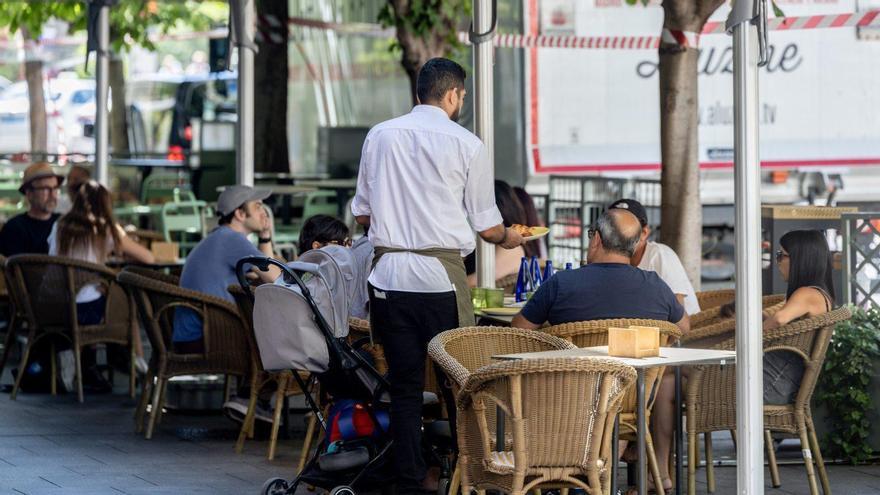 Un camarero sirve la comida en una terraza. |  Ricardo Rubio