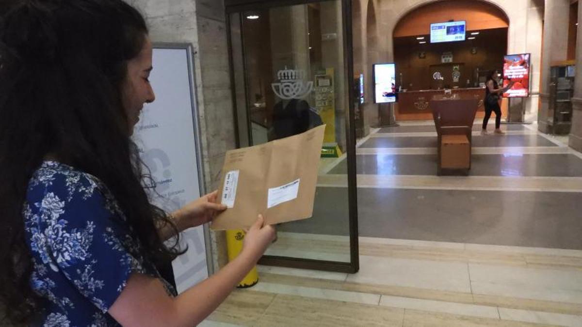Una gallega accede a una oficina de Correos para votar en Ourense