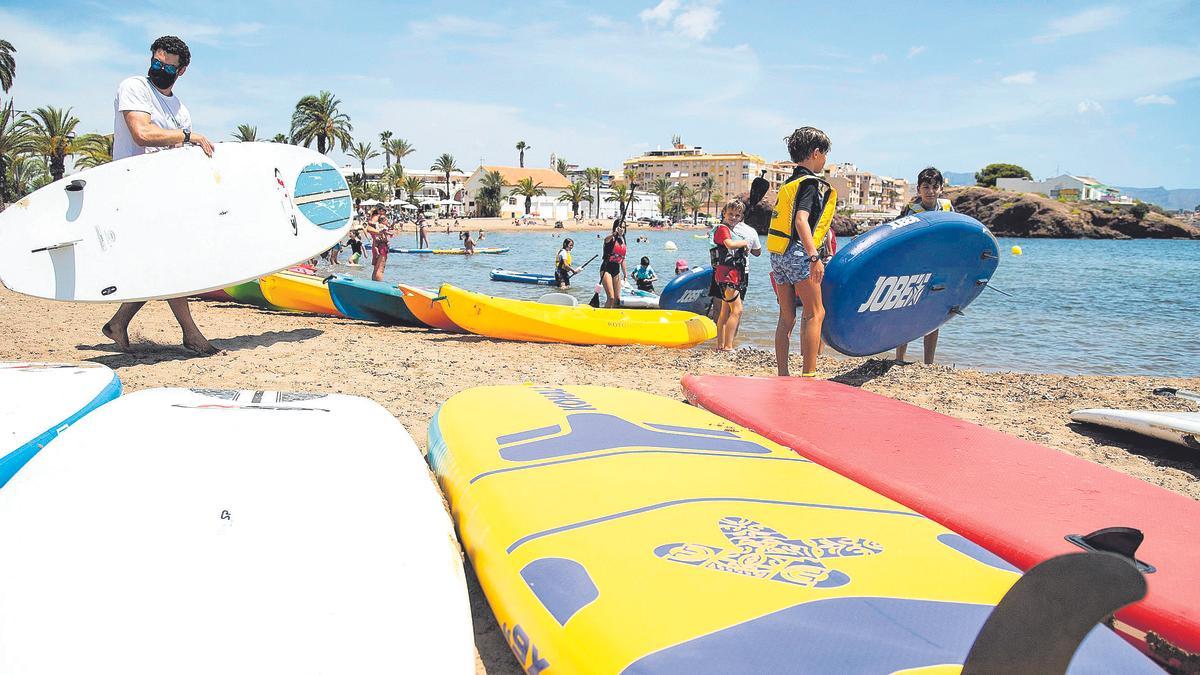 Niños preparándose para practicar surf en la costa de Mazarrón.