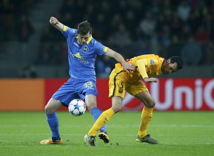 BATE Borisov's Signevich fights for ball with Barcelona's Busquets during their Champions League group E soccer match at Borisov Arena stadium outside Minsk
