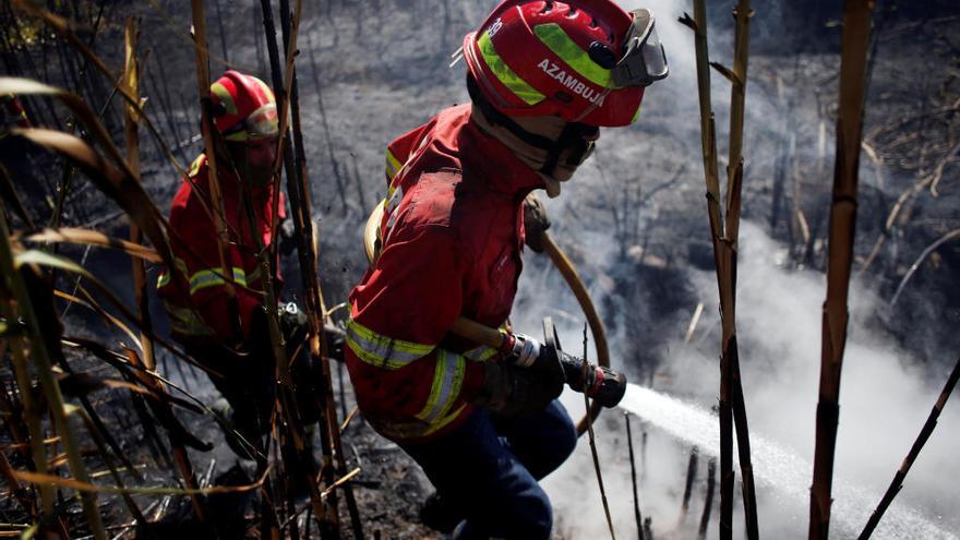 Dos bomberos en labores de extinción en Sintra. | Reuters