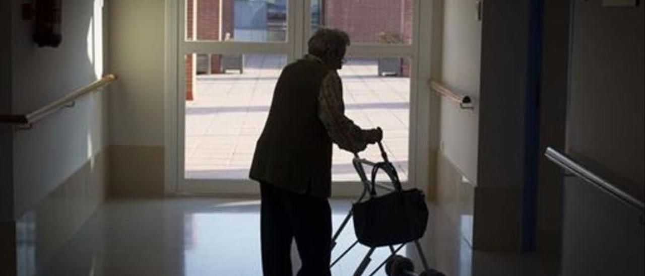 Una anciana pasea por el interior de una residencia de la tercera edad