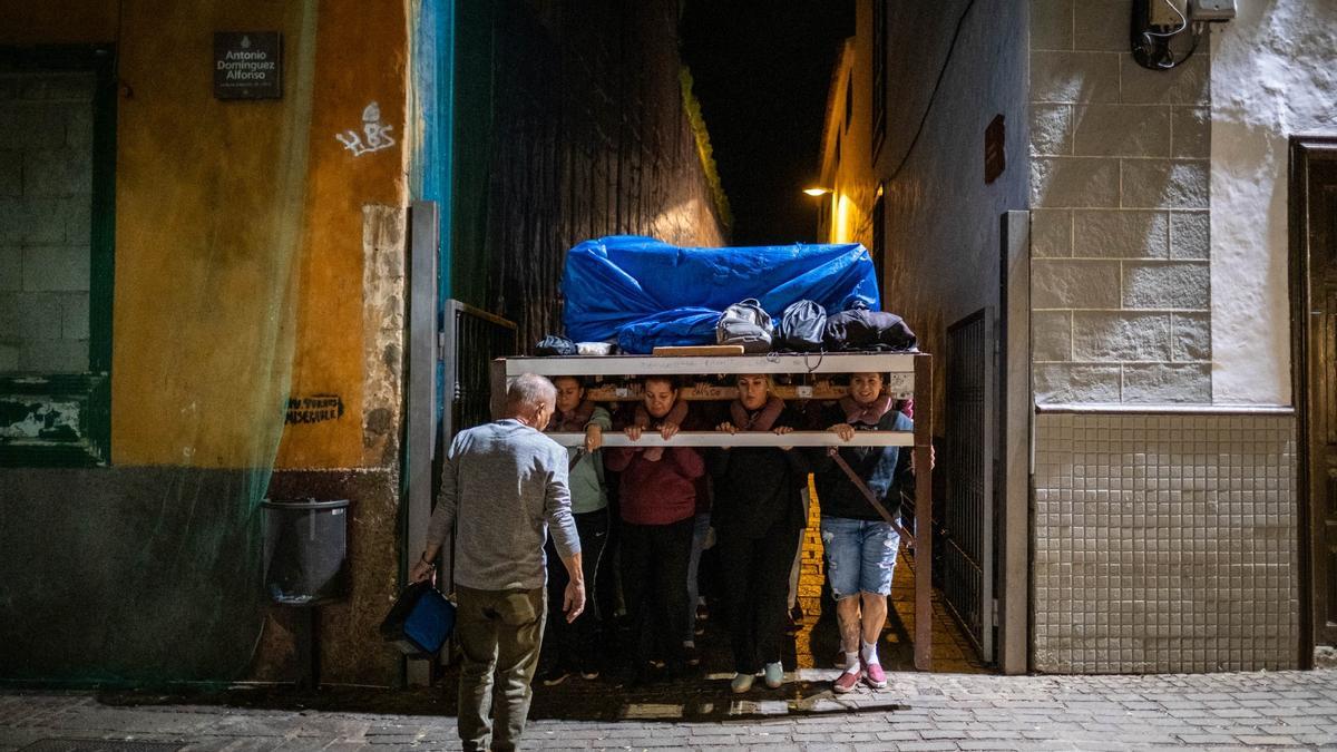 Las costaleras de El Cautivo sacan el trono del callejón Verdugo para comenzar su ensayo.