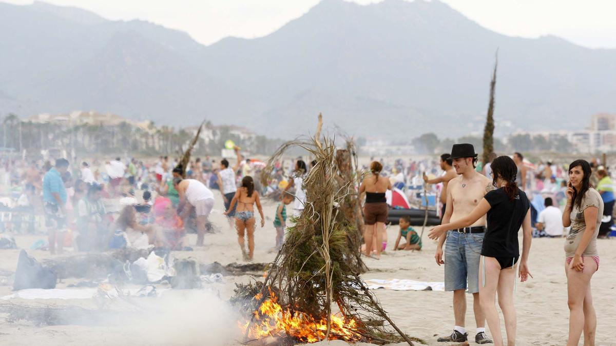 Grupos de personas celebran con hogueras sobre la arena de la playa la noche de San Juan en las playas de Castelló en una edición anterios.