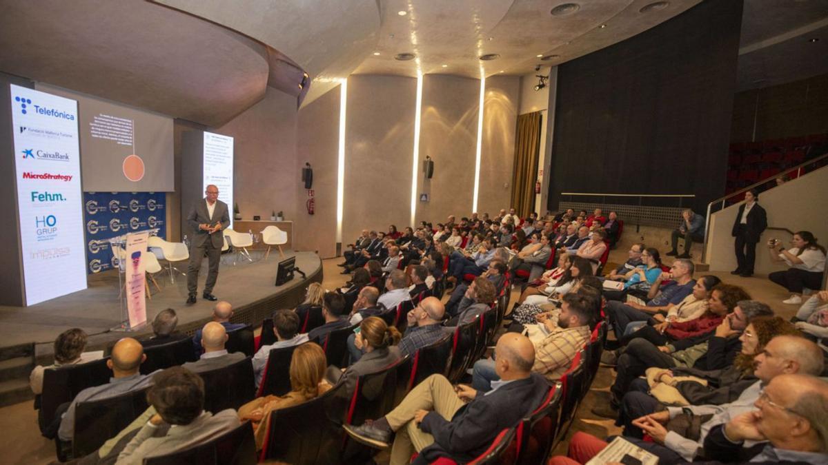 El público sigue la ponencia del economista Antoni Riera.