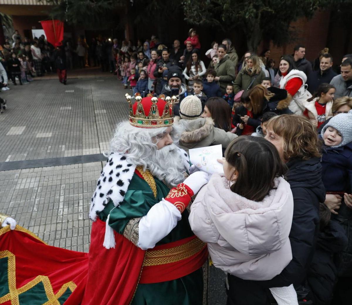 Varios niños reciben al Rey Baltasar en la entrada de la iglesia de San Nicolás de Bari, en El Coto. | Marcos León