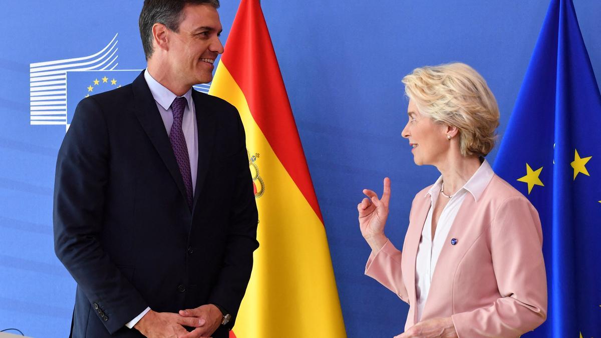 Spanish Prime Minister Pedro Sanchez (L) reacts next to European Commission President Ursula von der Leyen during a press conference on a new initiative for vaccine cooperation with Latin American and Caribbean countries at the EU Parliament in Brussels on June 22, 2022. (Photo by JOHN THYS / AFP)