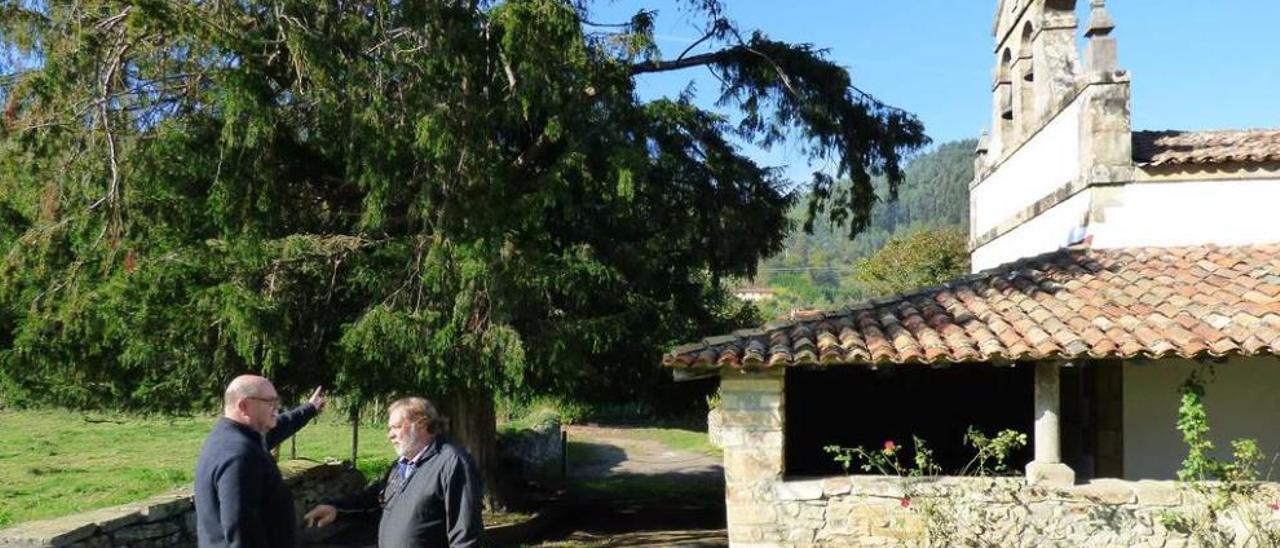 José Luis Muñoz y Luis Rivaya charlan delante del texu y de la iglesia de San Martín del Mar.