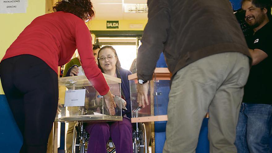 Una mujer en silla de ruedas vota en el Fernando II al no poder acercarse a la mesa.