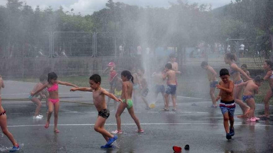 Los niños disfrutan de la fiesta del agua. // G. S.