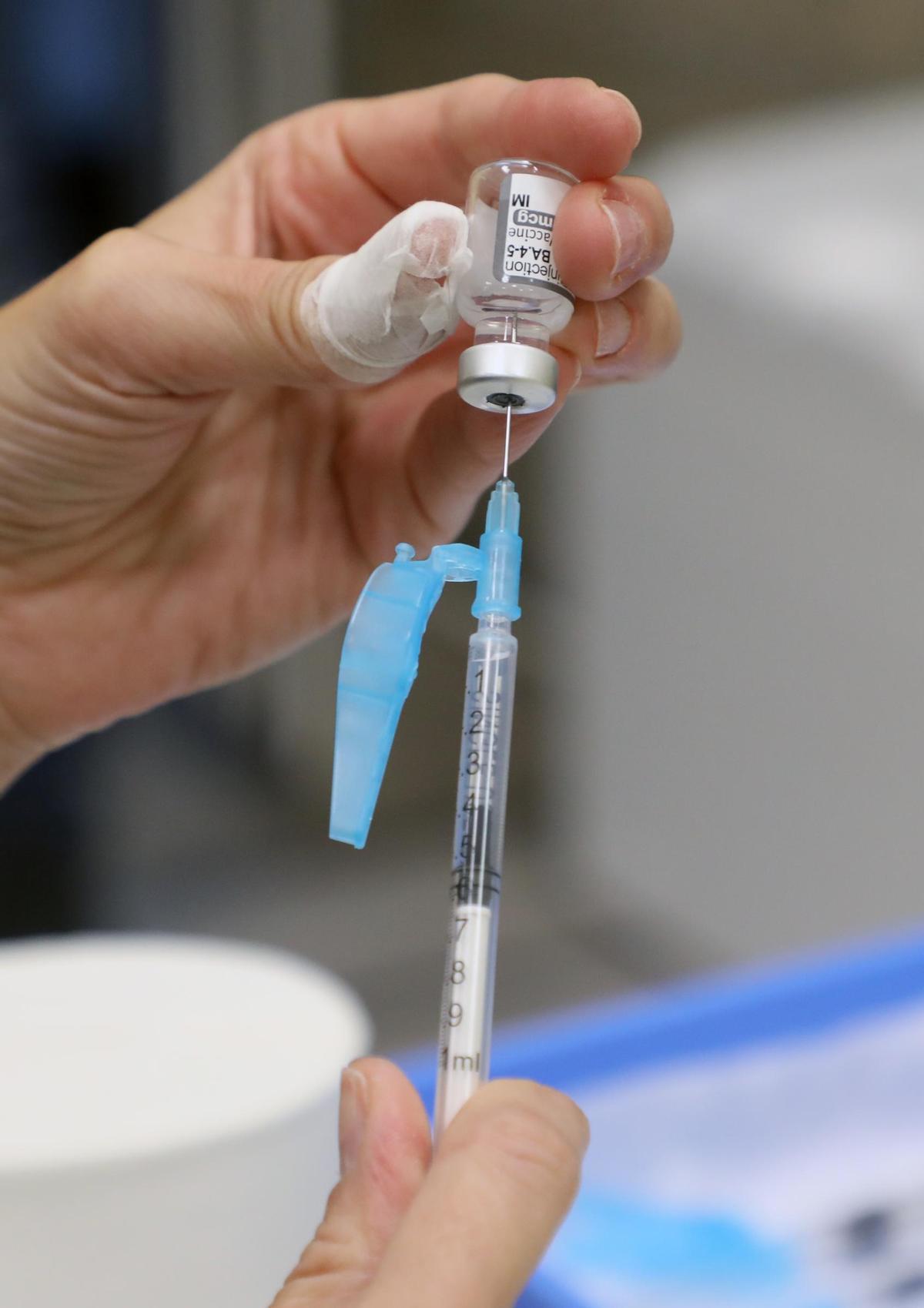 Una enfermera sostiene una vacuna