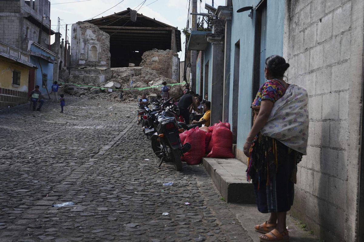 A woman stands next to the damaged El Calvario Catholic church in Santa Maria de Jesus, Guatemala, Wednesday, July 9, 2025. (AP Photo/Moises Castillo). EDITORIAL USE ONLY/ONLY ITALY AND SPAIN