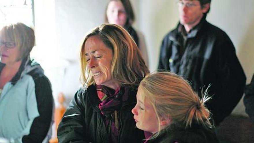 Una mujer llora desconsolada junto a su hija en un oficio religioso, en Newtown. / reuters