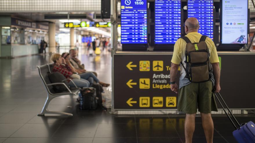 Un pasajero consulta el panel de salidas en un aeropuerto.