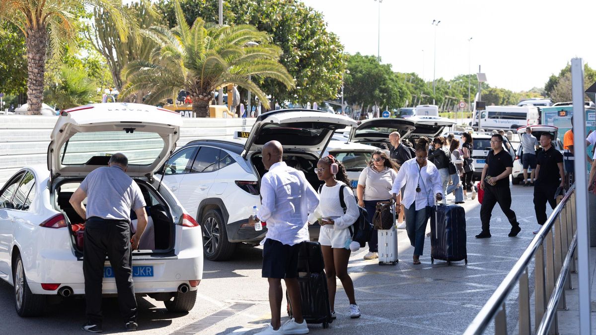 Diversos turistas acceden a un taxi en la parada del aeropuerto.