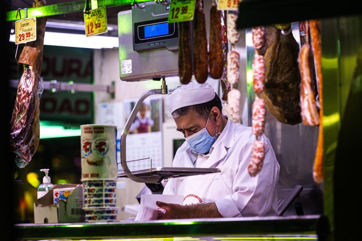 Un charcutero trabajando en el Mercado de Maravillas.