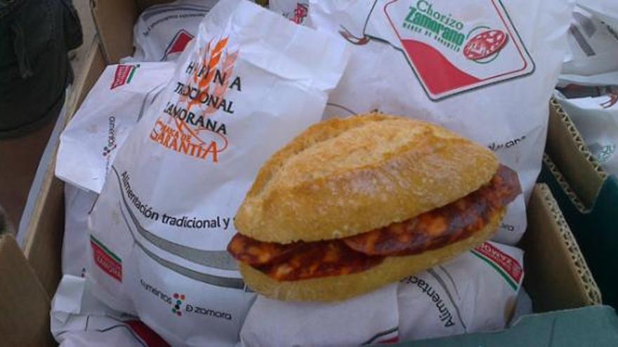 Una niña coge un bocadillo durante la merienda tradicional.