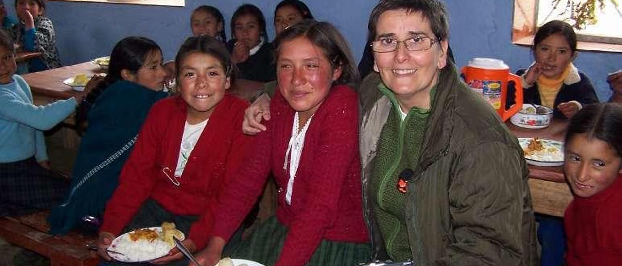 Pilar Muñoz, directora de Aulas Abiertas, con varias de las niñas que acuden a diario a uno de los comedores escolares de la ONG.