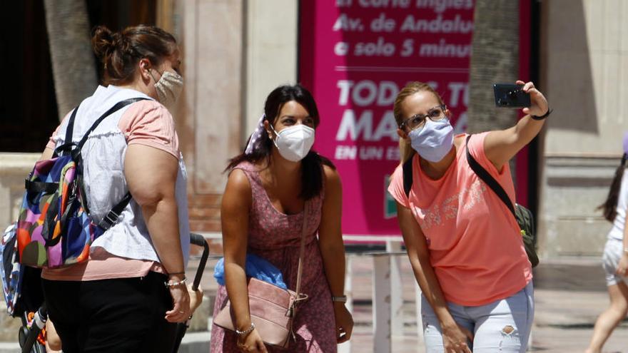 Un grup de persones es fa una foto mentre porten mascareta