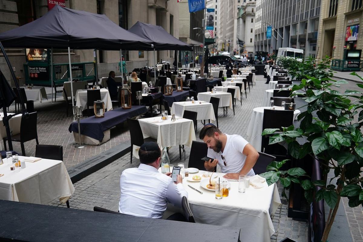 People eat at a mostly empty restaurant with tables on the street, in the financial district during the coronavirus disease (COVID-19) pandemic in the Manhattan borough of New York City, New York, U.S., September 9, 2020. Picture taken September 9, 2020. REUTERS/Carlo Allegri - RC2JWI9IBNGK