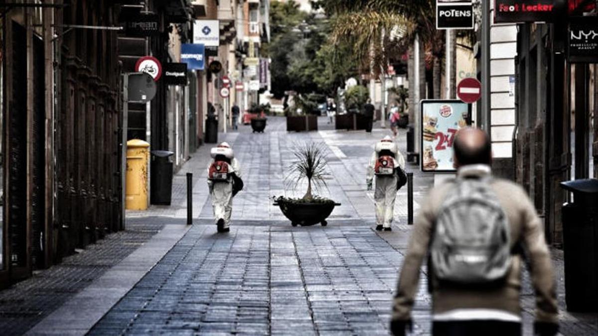 Dos operarios desinfectan la calle Castillo durante el confinamiento.