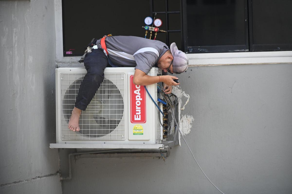 Un técnico de aire acondicionado instalando un aparato