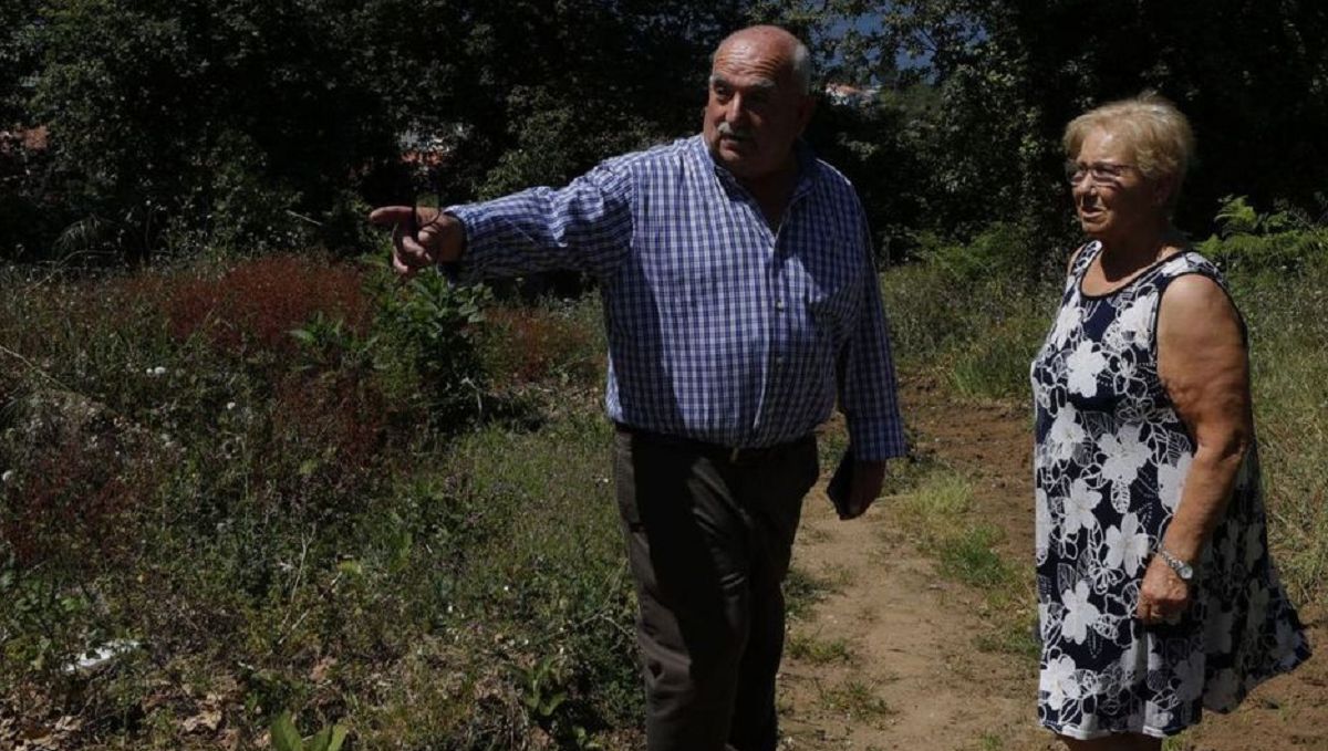 Carmen Reboreda mostrando al concejal de Obras, Vicente Lamas, el sendero hacia su casa.