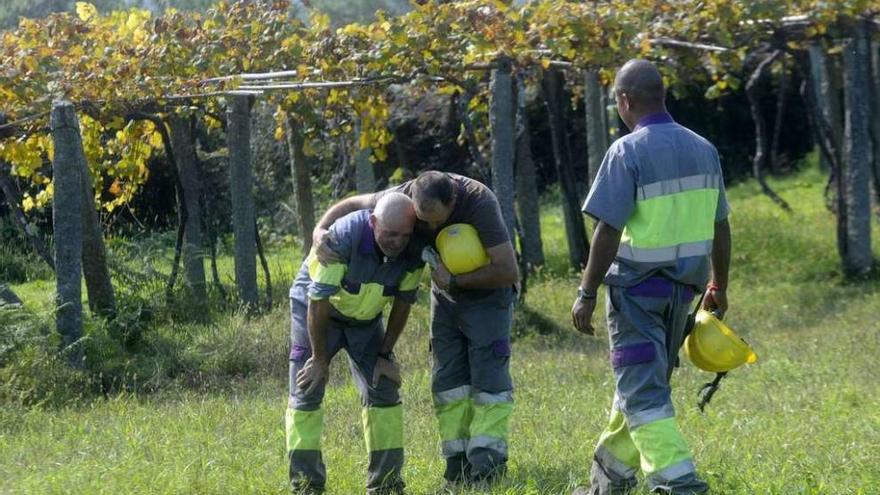 Dos trabajadores consolando a otro a escasos metros del lugar del accidente. // Noé Parga