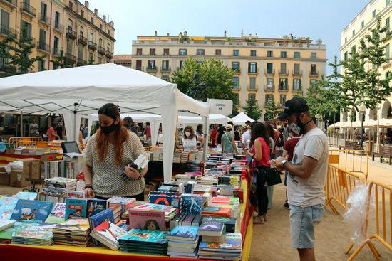 Circuits a les parades i gel hidroalcohòlic per poder fullejar llibres al Sant Jordi d'estiu a Girona.