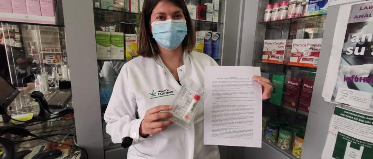 Trabajadora de la Farmacia Colomer, de Cangas, con los tubos para la recogida de muestras. |   // S.A.