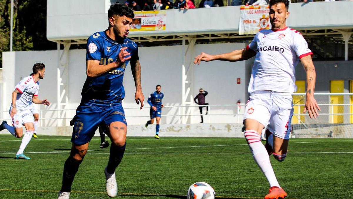 Isra Salazar lucha el esférico ante Cachana durante el encuentro contra el Utrera. | PRENSA UCAM MURCIA CF