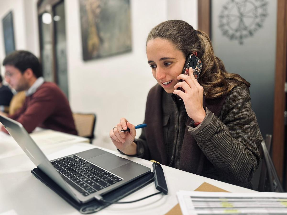 María Cabezas atendiendo a hermanos vía telefónica durante el reparto de papeletas de la hermandad.