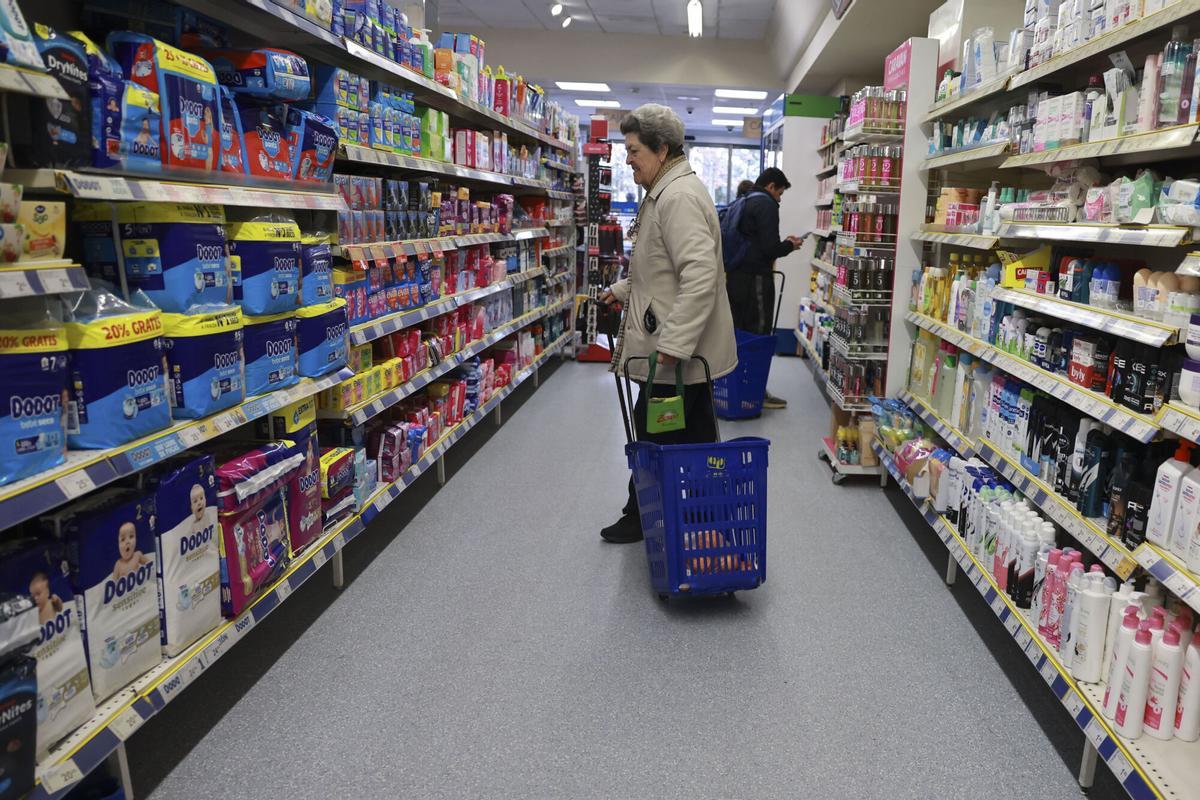 Una mujer observa los productos de un supermercado.