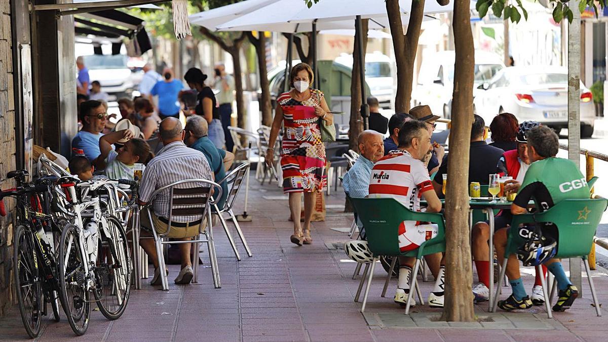 Vecinos de Santiago el Mayor, en una de las terrazas del barrio. Los comerciantes esperan que el consumo del barrio aumente tras la apertura del paso. | JUAN CARLOS CAVAL