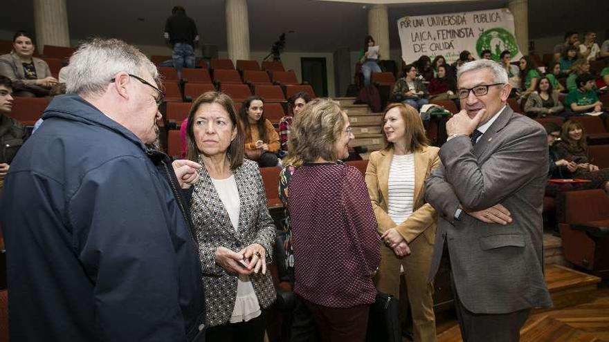 El rector, Santiago García Granda, a la derecha, charla con la defensora universitaria, Paz de Andrés, antes del inicio del claustro, celebrado en el Aula Magna de la Facultad de Economía y Empresa.