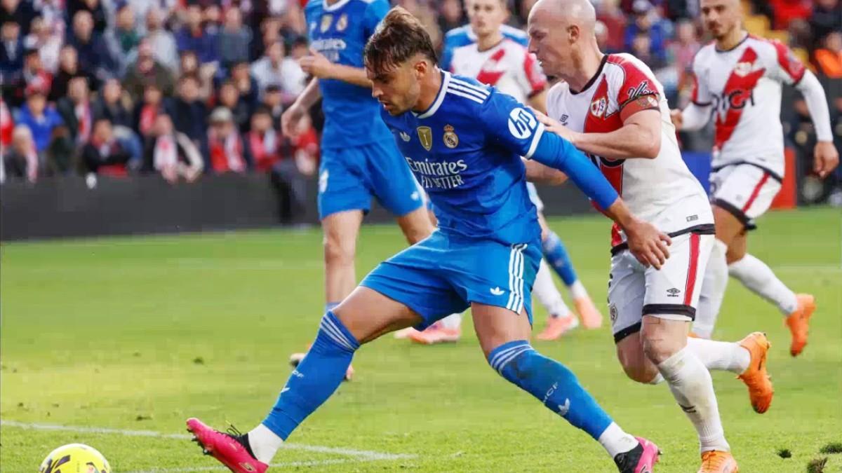 Asencio protege el balón ante Isi, en el último partido del Madrid jugado en Vallecas