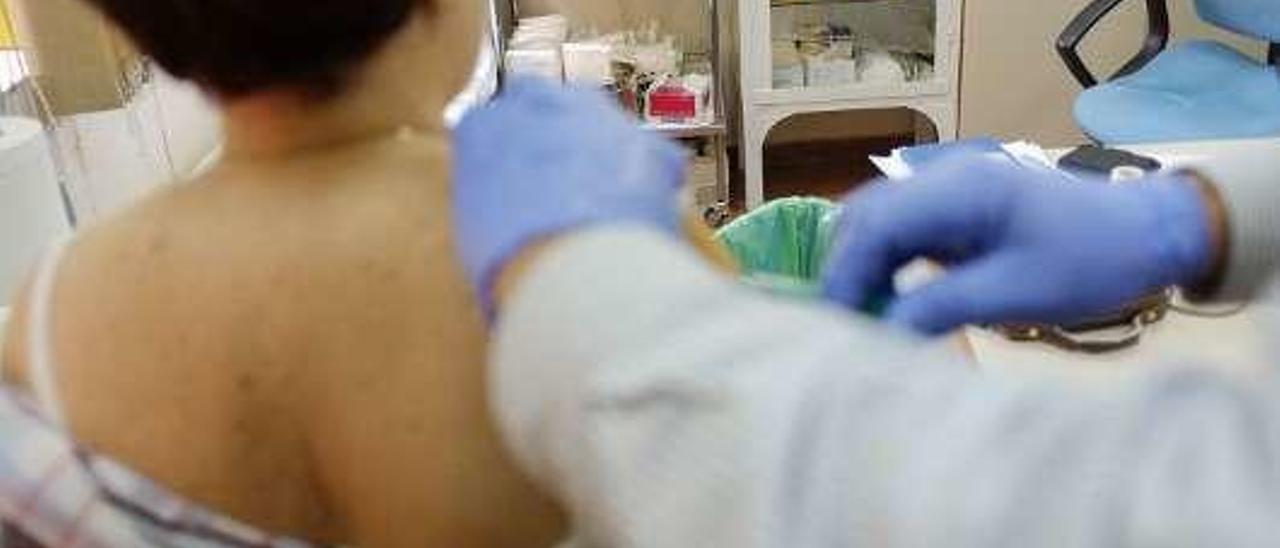 Una enfermera aplica la vacuna de la gripe a una paciente.