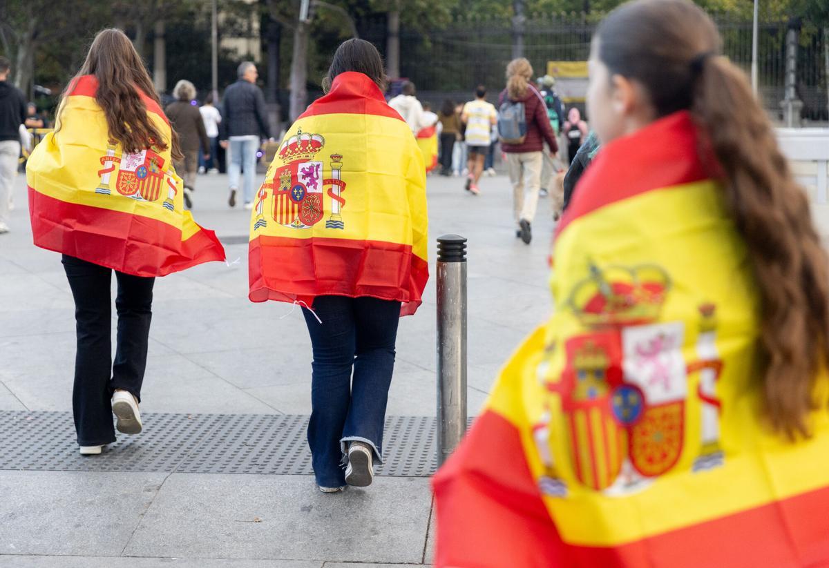 Público portando banderas de España antes del acto solemne de homenaje a la bandera nacional y desfile militar por el 12 de octubre, Día de la Hispanidad, en la Plaza de Cánovas del Castillo, a 12 de octubre de 2025, en Madrid (España). Los actos comienzan con el izado de bandera y van seguidos del homenaje a los que dieron la vida por el país. Posteriormente, comienzan los desfiles militares aéreos y terrestres. En total, 3.847 efectivos de las Fuerzas Armadas, las Fuerzas y Cuerpos de Seguridad del Estado y otras instituciones del Estado participarán en el desfile, junto a 229 caballos, 6 perros, 45 aviones y 29 helicópteros. 12 OCTUBRE 2025;DESFILE MILITAR;DÍA DE LA HISPANIDAD Eduardo Parra / Europa Press 12/10/2025. Eduardo Parra;